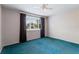 Bedroom with turquoise carpet, ceiling fan and window with curtains at 8413 Lincolnshire Dr, Hudson, FL 34667