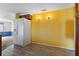 Kitchen area with updated tile flooring, yellow accent wall, and white refrigerator at 8413 Lincolnshire Dr, Hudson, FL 34667