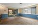 Living room with sliding glass doors to the screened lanai and blue paneled walls at 8413 Lincolnshire Dr, Hudson, FL 34667