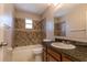 This bathroom has a shower-tub combo with unique mosaic-style tile accents and granite counters at 8730 Filson Pl, Sarasota, FL 34231