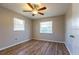 This bedroom has wood flooring, two windows for ample natural light, and a ceiling fan for comfort at 8730 Filson Pl, Sarasota, FL 34231