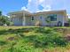 Charming single-story home with a covered entrance, well-maintained lawn, and mature trees at 8730 Filson Pl, Sarasota, FL 34231