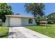 Front view of the house with a concrete driveway, attached garage, and neatly manicured lawn at 8730 Filson Pl, Sarasota, FL 34231