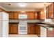 Bright kitchen with wooden cabinets, light countertops, white appliances and a double stainless steel sink at 8730 Filson Pl, Sarasota, FL 34231