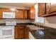 A well-lit kitchen featuring wooden cabinets, sleek countertops, stainless steel sink, and modern appliances at 8730 Filson Pl, Sarasota, FL 34231