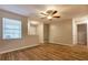 Bright living room featuring wood floors, ceiling fan, and large window letting in natural light at 8730 Filson Pl, Sarasota, FL 34231