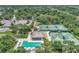 Aerial view of tennis courts, a pool, and clubhouse amidst lush trees and landscaping at 8731 52Nd E Dr, Bradenton, FL 34211