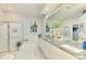 Well-lit bathroom featuring a large vanity, soaking tub, and glass-enclosed shower at 8731 52Nd E Dr, Bradenton, FL 34211