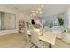 Bright dining area with chandelier, modern decor, and view of the pool and outdoor living space at 8731 52Nd E Dr, Bradenton, FL 34211