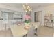 Dining area featuring modern light fixture, bar seating, and views to the living spaces at 8731 52Nd E Dr, Bradenton, FL 34211