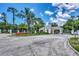 Welcoming community entrance with a guard house, beautiful landscaping, and palm trees at 8731 52Nd E Dr, Bradenton, FL 34211