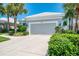 Exterior showcases lush greenery and a well-maintained driveway leading to a two-car garage at 8731 52Nd E Dr, Bradenton, FL 34211