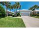 Charming home with a well-manicured front yard, complemented by lush landscaping and swaying palm trees at 8731 52Nd E Dr, Bradenton, FL 34211