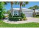 Charming home with a well-manicured front yard, complemented by lush landscaping and swaying palm trees at 8731 52Nd E Dr, Bradenton, FL 34211