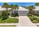 Charming home with a well-manicured front yard, complemented by lush landscaping and swaying palm trees at 8731 52Nd E Dr, Bradenton, FL 34211