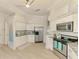 Stylish kitchen equipped with stainless appliances, light wood floors, and white cabinetry at 8731 52Nd E Dr, Bradenton, FL 34211