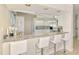 Kitchen bar with white stools, granite countertop and view to the kitchen area at 8731 52Nd E Dr, Bradenton, FL 34211