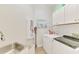 Bright laundry room includes modern washer/dryer and ample cabinet space at 8731 52Nd E Dr, Bradenton, FL 34211