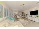 Spacious living room with view to the dining area, white furniture and a wall-mounted television at 8731 52Nd E Dr, Bradenton, FL 34211