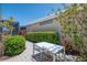 Outdoor patio with modern table and chairs, surrounded by lush, colorful landscaping at 8731 52Nd E Dr, Bradenton, FL 34211