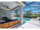 Inviting screened-in lanai with pool, comfortable seating, and ceiling fan at 8731 52Nd E Dr, Bradenton, FL 34211
