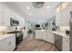 Modern kitchen with white cabinets, stainless steel appliances, and wood-look flooring, open to the living area at 9635 Discovery Ter, Bradenton, FL 34212