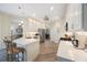 Bright, open kitchen featuring white cabinetry, a center island, and stainless steel appliances on wood-look flooring at 9635 Discovery Ter, Bradenton, FL 34212