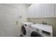 Functional laundry room with white cabinetry and appliances at 9635 Discovery Ter, Bradenton, FL 34212