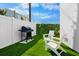 Backyard features Adirondack chairs, artificial turf, and a barbecue grill at 103 4Th N St # A, Bradenton Beach, FL 34217