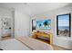 Bright bedroom featuring a ceiling fan, console table with a coastal view through the windows at 103 4Th N St # A, Bradenton Beach, FL 34217