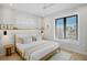 Bright bedroom featuring large window, white bedding, and accent wall at 103 4Th N St # A, Bradenton Beach, FL 34217