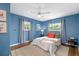 Bright blue bedroom with natural light from two windows and a neutral bed at 1040 Hope St, Venice, FL 34285
