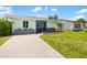 Cozy home featuring an easy concrete driveway and green grass, nestled in a sunny locale at 1040 Hope St, Venice, FL 34285