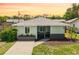 Charming home with manicured lawn, gray roof and accents, complemented by flowering bushes at 1040 Hope St, Venice, FL 34285