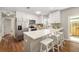 Bright kitchen with stainless steel appliances, white cabinets, and a breakfast bar with three white bar stools at 1040 Hope St, Venice, FL 34285