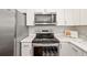 Stainless steel microwave and range oven sit beneath bright white cabinetry in the modern kitchen at 1040 Hope St, Venice, FL 34285