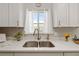 Kitchen sink with a window, bright white cabinets, and a sleek stainless steel faucet at 1040 Hope St, Venice, FL 34285