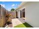 Cozy patio with lush plants and flowers, exterior door, and a small turf area at 1040 Hope St, Venice, FL 34285
