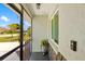 Screened porch with a light-green wall, dark-grey rock facade, window, and tiled floor at 1040 Hope St, Venice, FL 34285