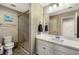 Bright bathroom with a glass-enclosed shower, white vanity, and neutral tile floor at 11411 Spring Gate Trl, Bradenton, FL 34211