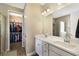 Modern bathroom with dual sinks, white cabinets, and a walk-in closet at 11411 Spring Gate Trl, Bradenton, FL 34211