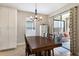 Dining room with a large table, contemporary lighting, and sliding glass doors leading to an outdoor seating area at 11411 Spring Gate Trl, Bradenton, FL 34211