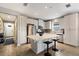 Modern kitchen featuring stainless steel appliances, white cabinets, a center island with seating, and wood-look tile flooring at 11411 Spring Gate Trl, Bradenton, FL 34211