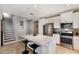 Bright kitchen with stainless steel appliances, white cabinetry, an island with seating, and access to the staircase at 11411 Spring Gate Trl, Bradenton, FL 34211