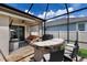 Enclosed patio with grill, seating, counter space, and a ceiling fan at 11411 Spring Gate Trl, Bradenton, FL 34211