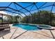 A stunning screened-in pool area with a luxurious in-ground pool, attached spa, and lush tropical landscaping at 11411 Spring Gate Trl, Bradenton, FL 34211
