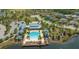 Stunning aerial view of a community pool, clubhouse, and surrounding homes amidst lush landscaping and a lake at 11603 Bluebird Pl, Lakewood Ranch, FL 34211