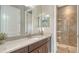 Well-lit bathroom featuring granite countertops, a vanity with sink, tiled floors, and a glass enclosed shower at 11603 Bluebird Pl, Lakewood Ranch, FL 34211