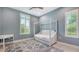 Inviting bedroom with canopy bed, white trim and window casing, neutral paint, and stylish area rug at 11603 Bluebird Pl, Lakewood Ranch, FL 34211