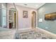 Bright bedroom with neutral paint, view into bathroom, arched doorways, and stylish area rug at 11603 Bluebird Pl, Lakewood Ranch, FL 34211